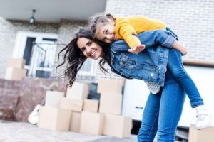 mother young daughter in front of new home