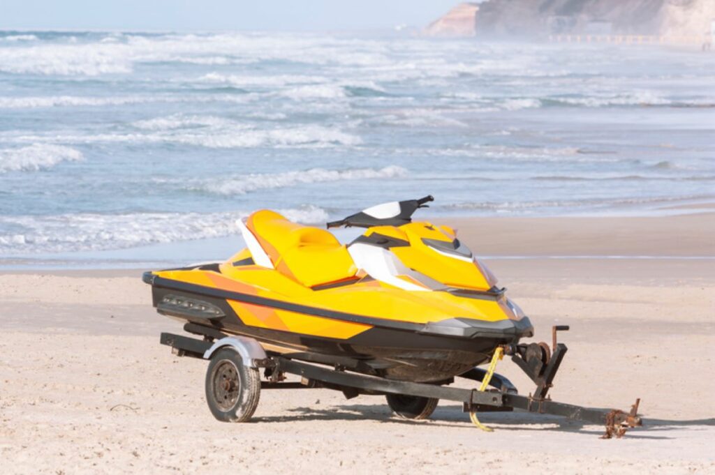 Jetski parked in the sand next to a beach.