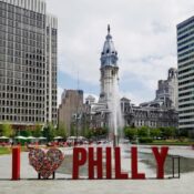 I Heart Philly sign with City Hall in the background at the corner of Market St and Broad St downtown Philly